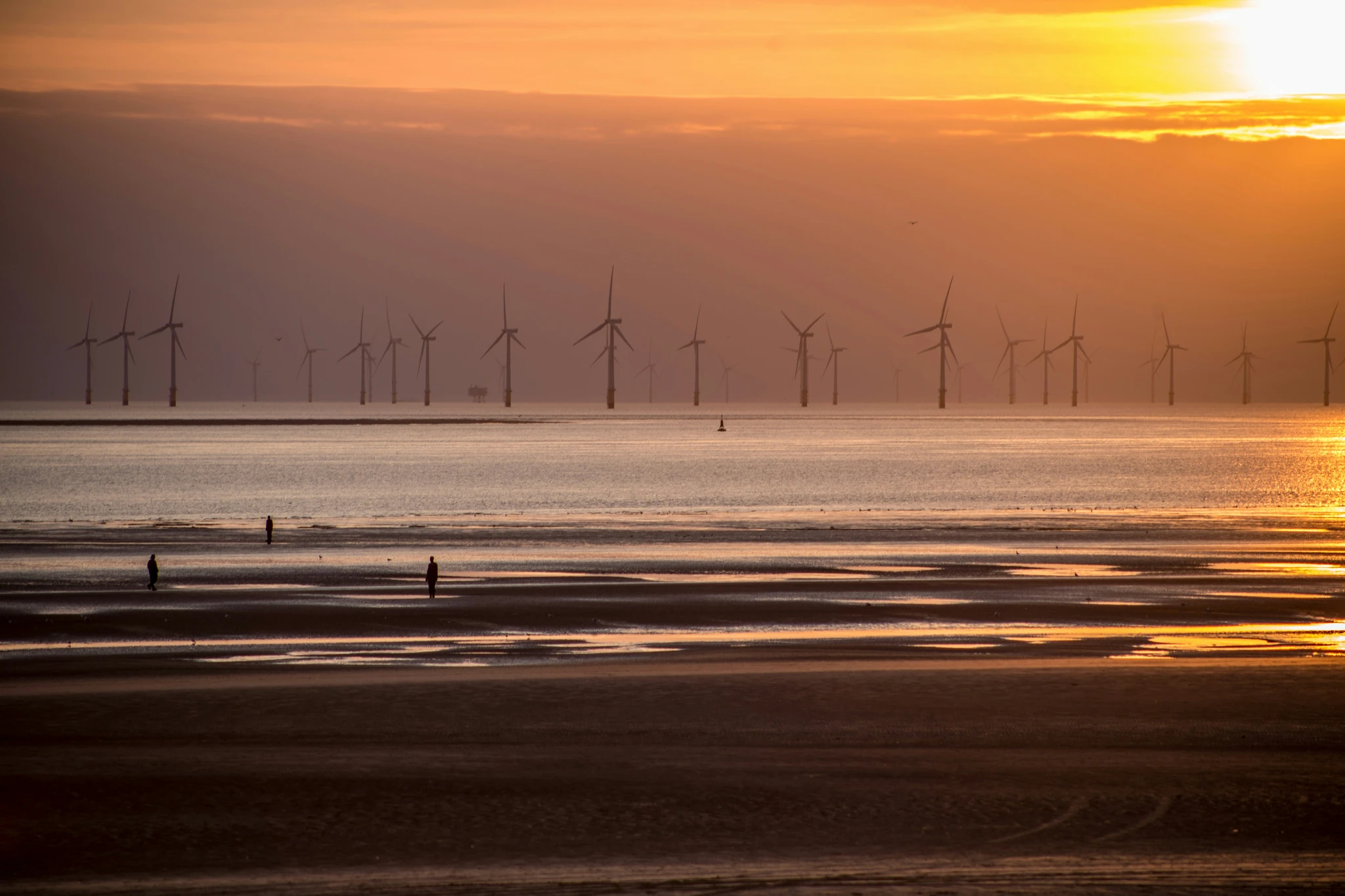 Offshore wind turbines on the horizon at sunset