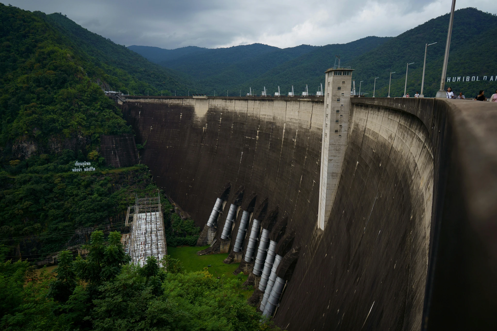 A concrete dam in a forested valley