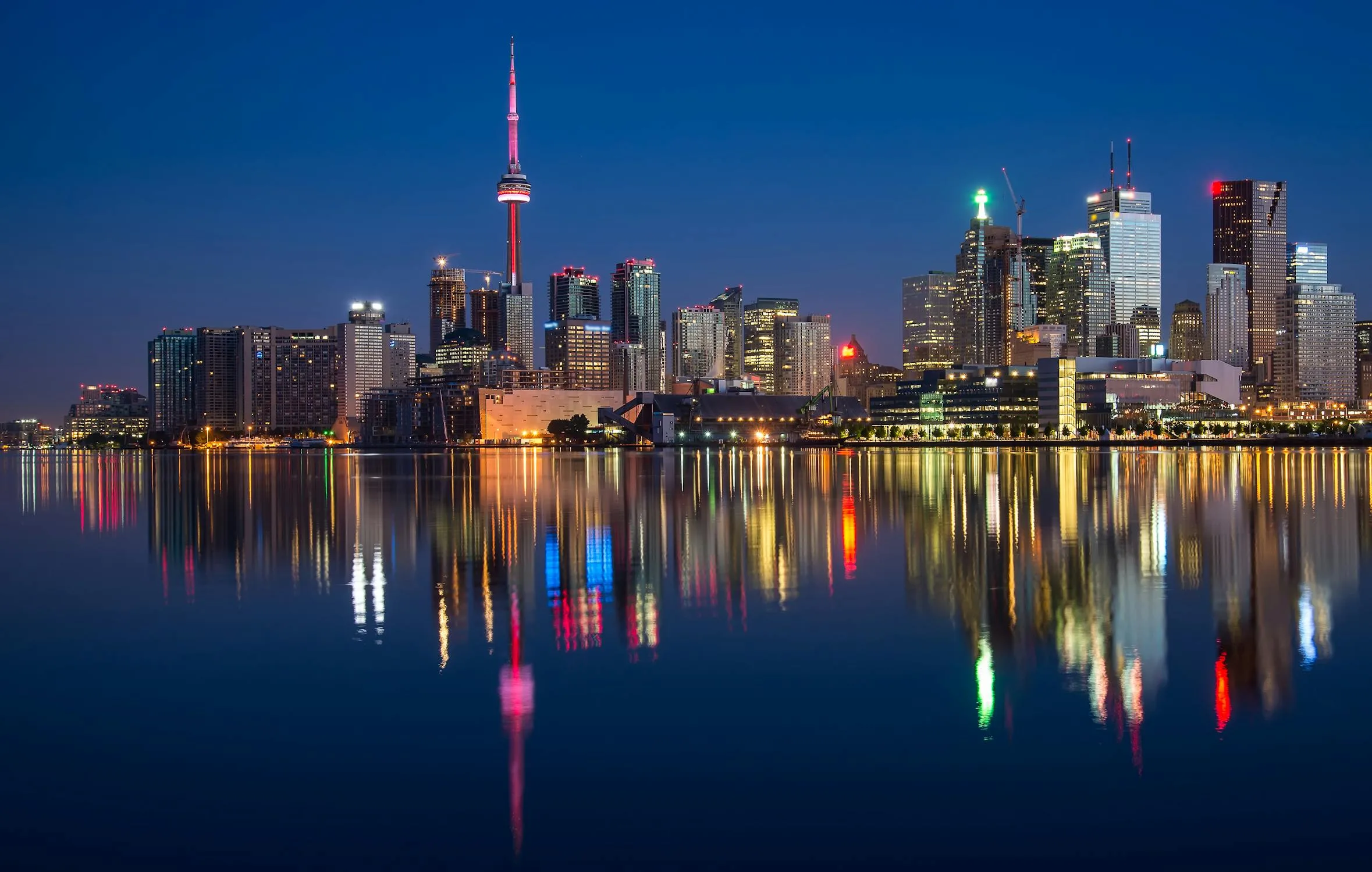 Global business district with modern glass buildings reflecting a cloudy sky
