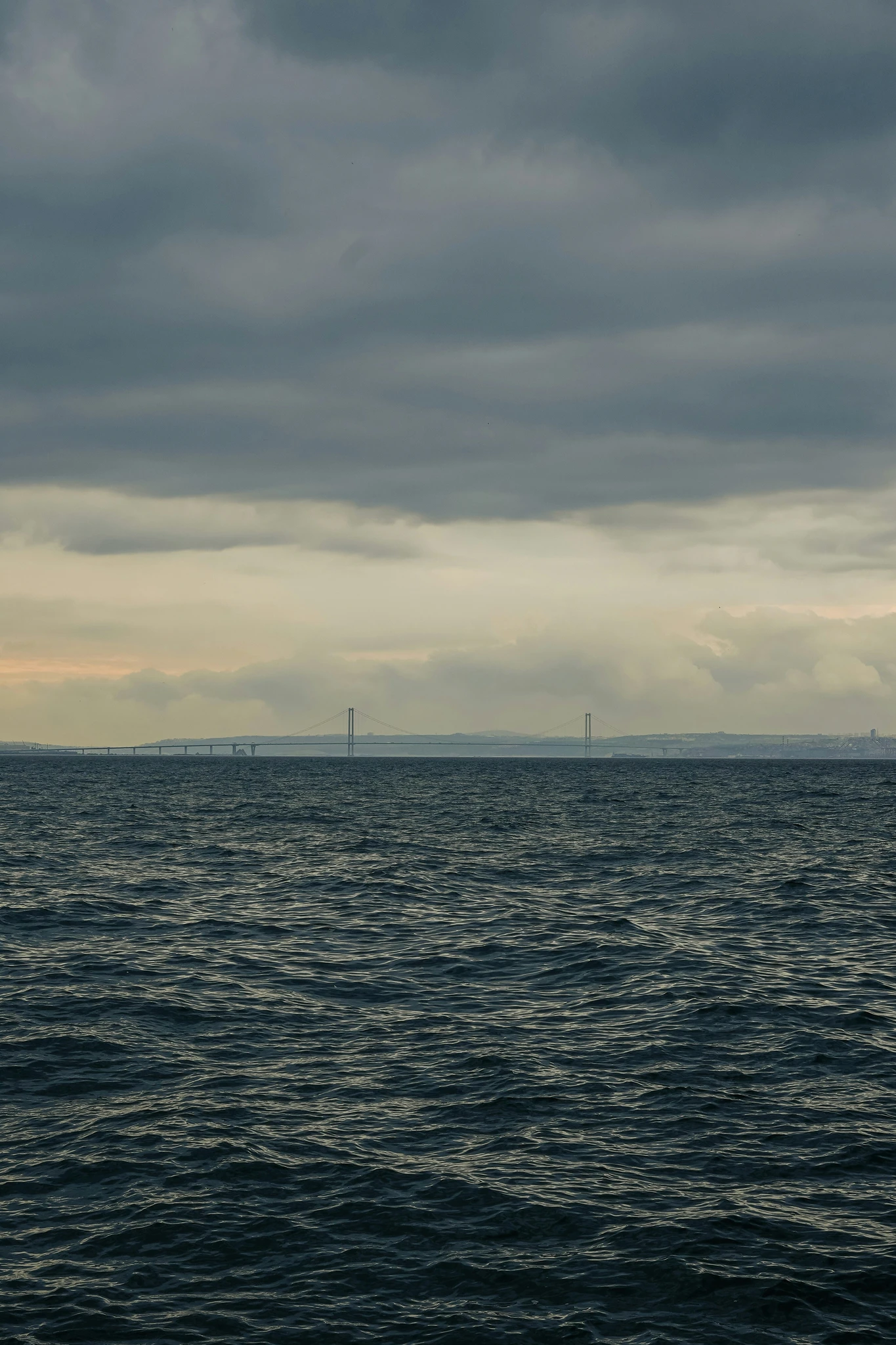 Distant wind turbines on a gray sea