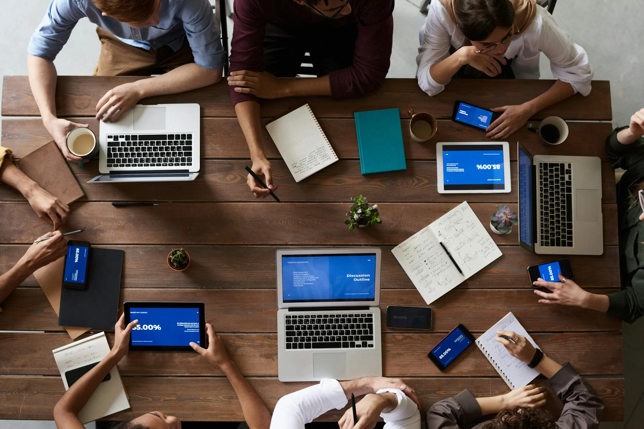 Team collaborating around a conference table with laptops and documents