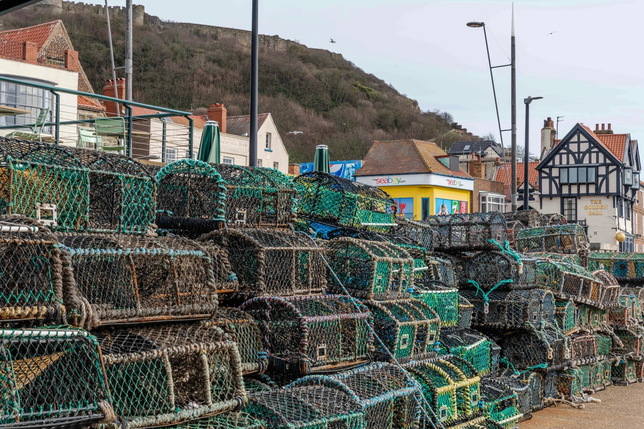 Lobster traps stacked on a harbor wharf