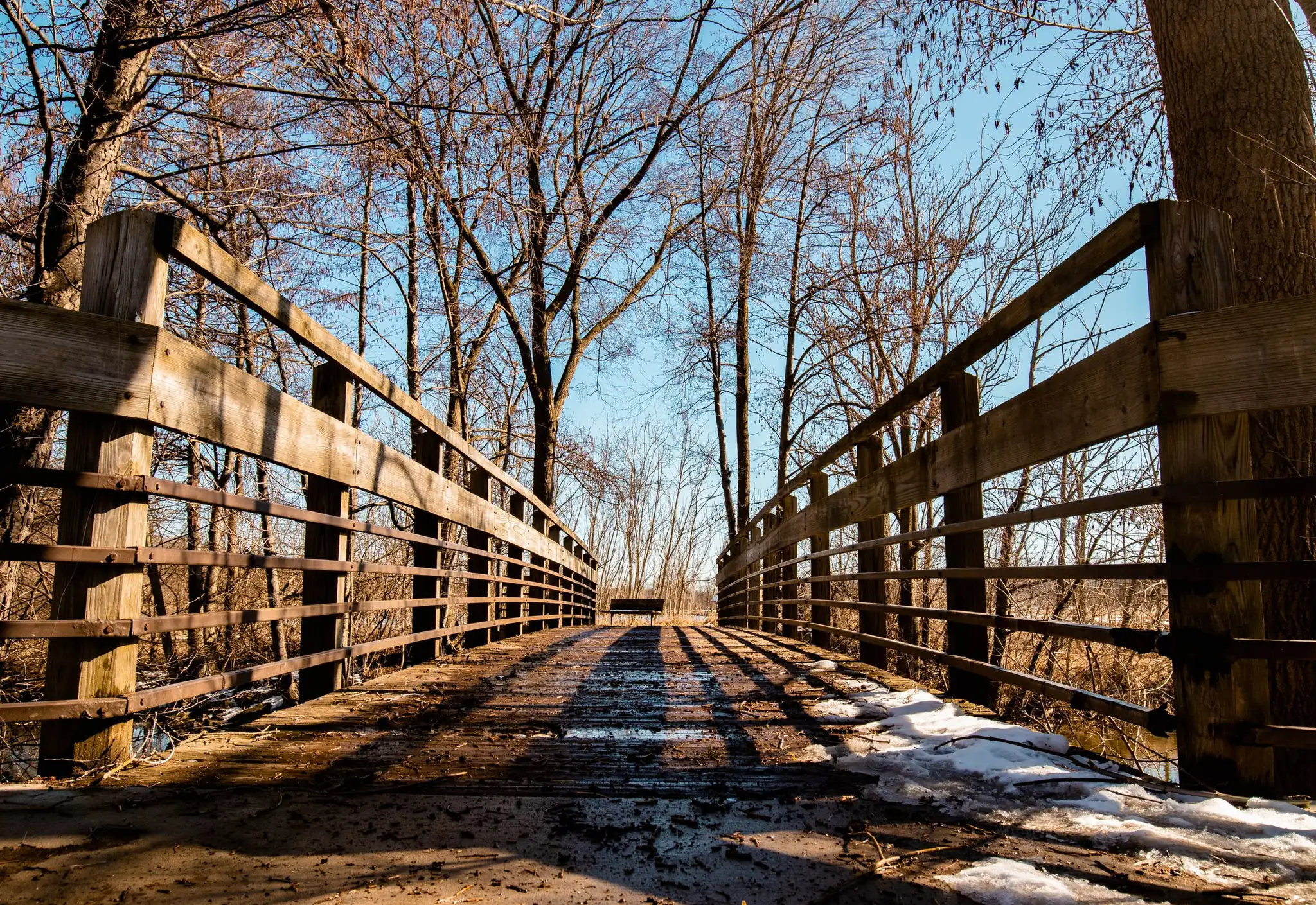 A wooden footbridge in winter in an Ann Arbor park